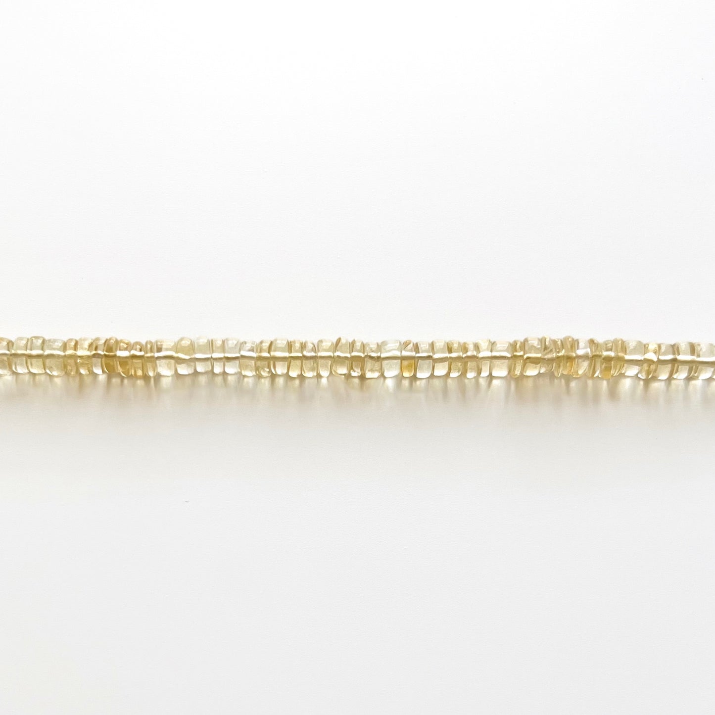 Close up strand of citrine beaded gemstone necklace with golden yellow orange smooth rondelle beads that are translucent in color