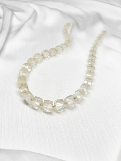 Lemon Quartz beaded gemstone necklace with light yellow faceted cube beads and 14k gold filled clasp and accent beads with a minimalist design on a soft white fabric background
