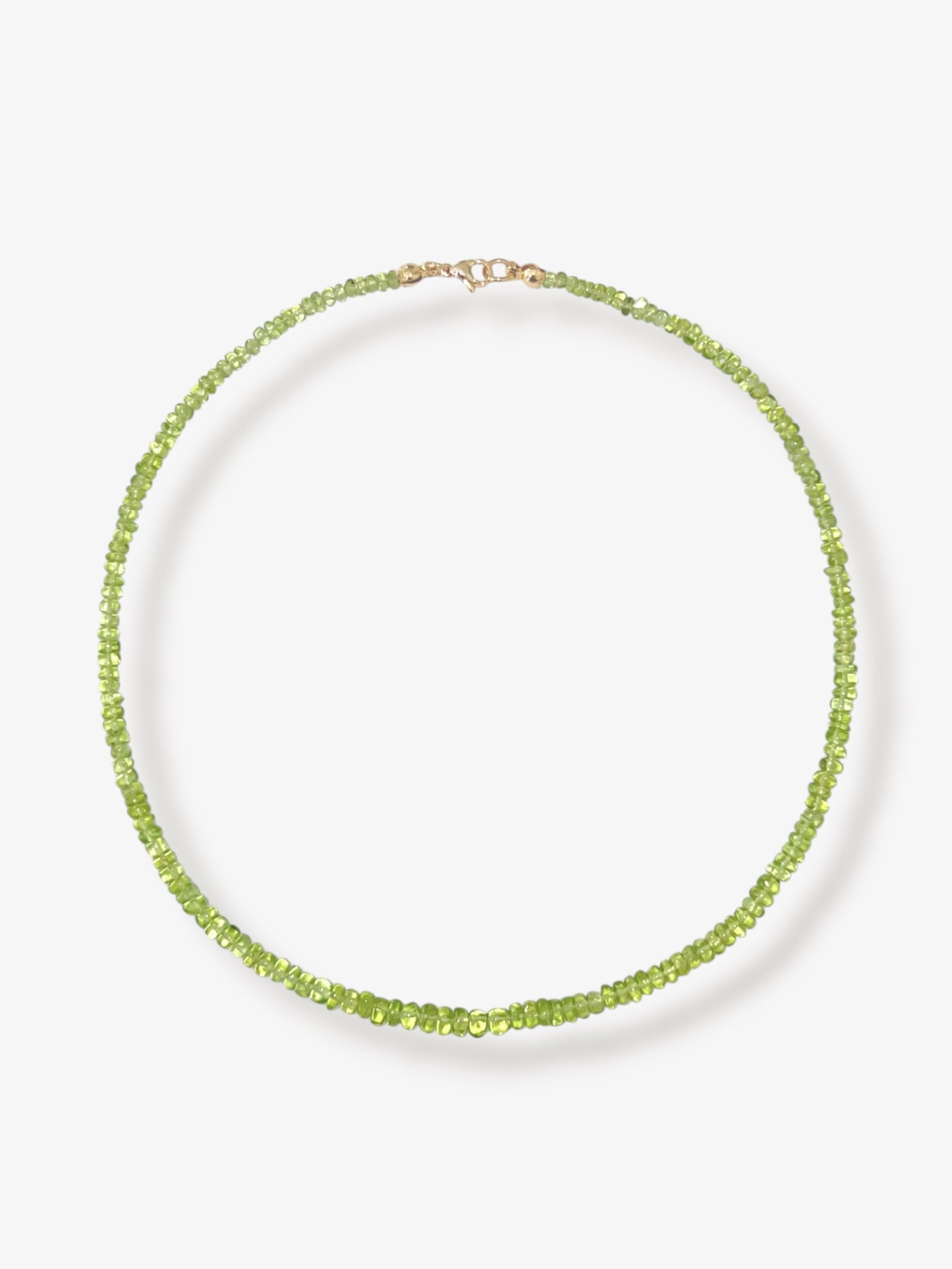 Peridot beaded gemstone necklace with green smooth rondelle beads and 14k solid gold or gold filled clasp with a minimalist design on a neutral background