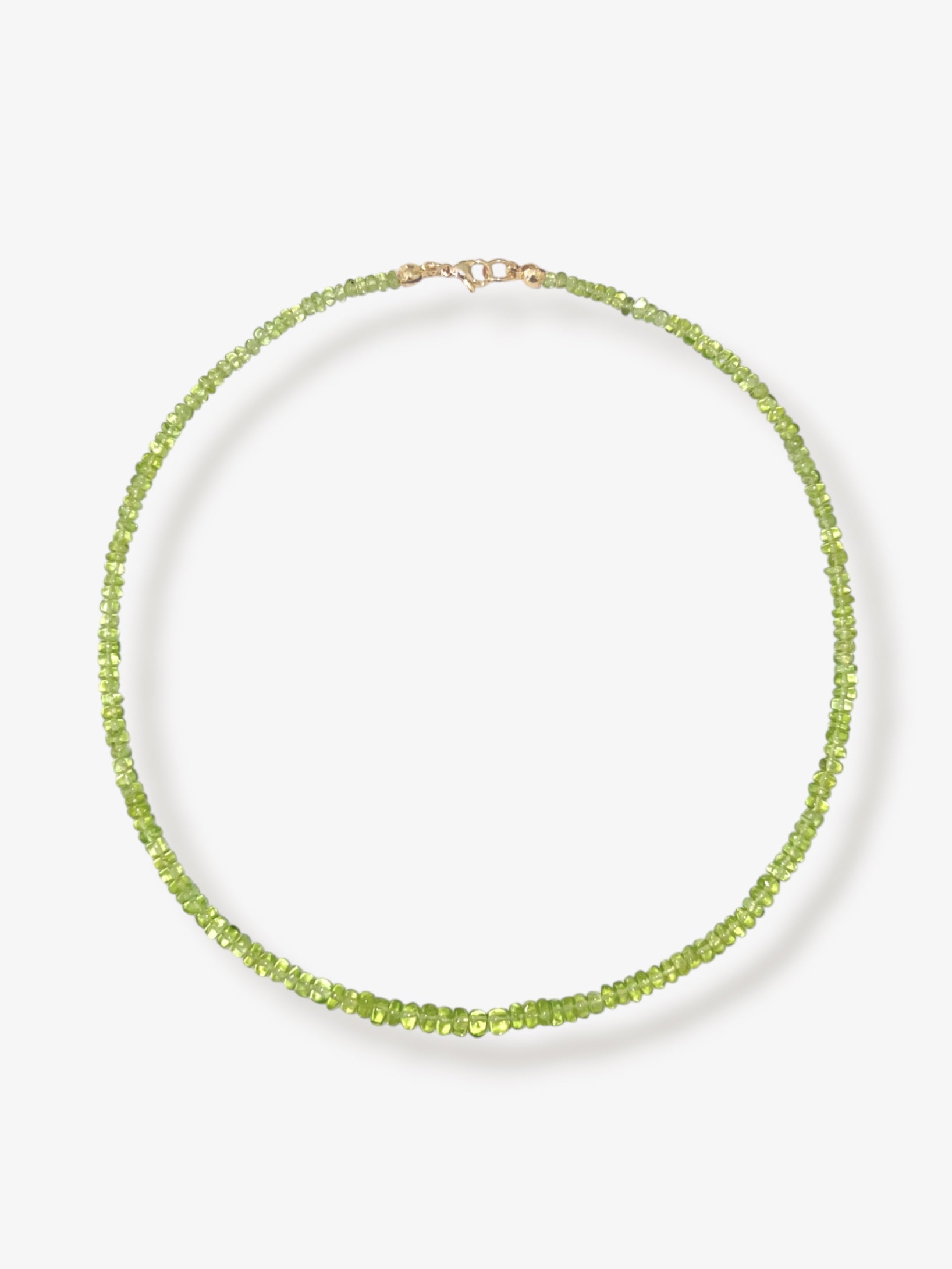 Peridot beaded gemstone necklace with green smooth rondelle beads and 14k solid gold or gold filled clasp with a minimalist design on a neutral background