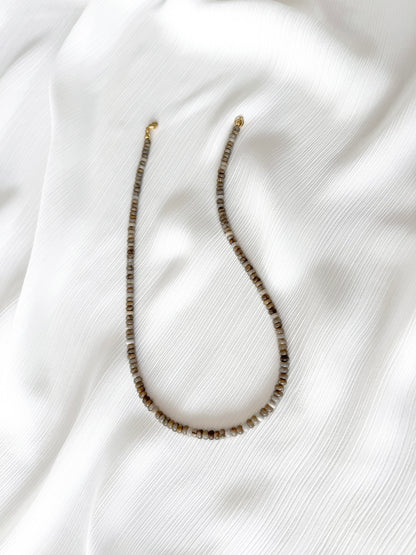 Dainty silver leaf jasper beaded gemstone necklace with rondelle beads featuring a multi-tone or neutral shades including beige, tan, brown, grey, and white with smooth polished finish completed with 14k gold filled or solid gold clasp with a minimalist design on a soft white fabric background